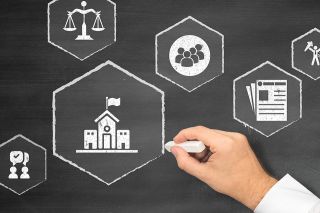 © CrazyCloud - stock.adobe.com Foto: Person malt Zeichen auf Tafel mit Kreide